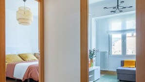 A hallway with patterned floor tiles leading to a bedroom with a bed and a hanging light fixture. - AH La Crème de la Crème. Oviedo. ENT200112814125 (Oviedo)