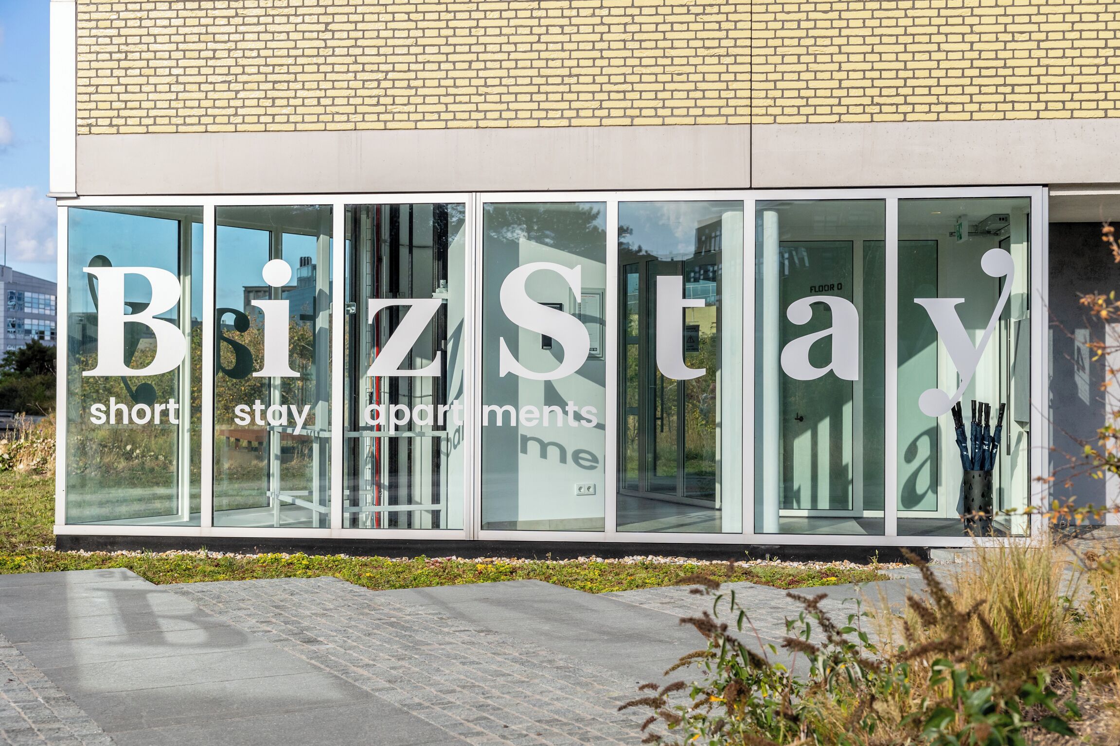 A building with large windows displaying the text "BizStay short stay apartments."