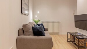 Una sala de estar moderna con un sofá, un televisor y un radiador.