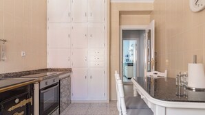A modern kitchen with white cabinets, a black countertop, and a marble backsplash. - AH Apartment Urban Lena VUT-6048-AS (Pola de Lena)