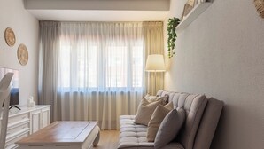 A modern living room with a sofa, a coffee table, a TV, and a lamp. - AH Apartment Urban Lena VUT-6048-AS (Pola de Lena)