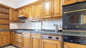 A kitchen with wooden cabinets, a stainless steel sink, a built-in oven, and a dishwasher. - Asturias holidays by Gestión house 3 (Noreña)