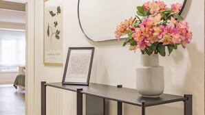 A modern console table with a vase of flowers, a framed picture, and a large mirror on the wall. - Asturias holidays by Gestión house 3 (Noreña)