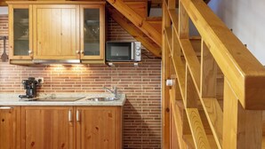 Eine Küche mit Holzschränken, einer Mikrowelle und einer Kaffeemaschine.