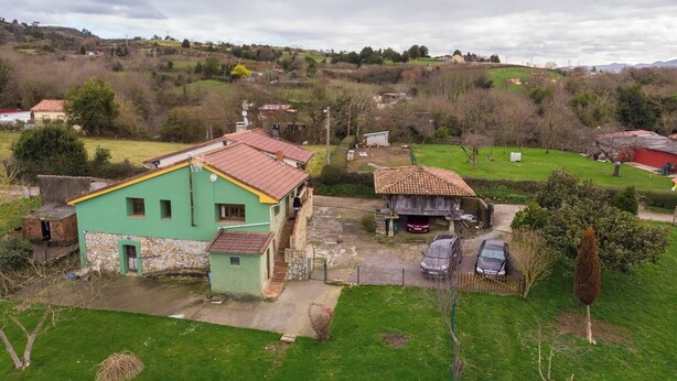 A rural house with a green exterior and a red roof, surrounded by a grassy yard and a small garden. - AH Townhouse "La Casina de Cués". VV-1762-AS (Asturias)