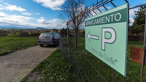 A sign for a parking area with a car parked nearby. - AH Townhouse "La Casina de Cués". VV-1762-AS (Asturias)