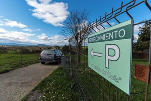 A sign for a parking area with a car parked nearby. - AH Townhouse "La Casina de Cués". VV-1762-AS (Asturias)