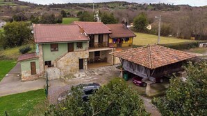 A two-story house with a tiled roof, a balcony, and a small attached structure with a tiled roof. - AH Townhouse "La Casina de Cués". VV-1762-AS (Asturias)
