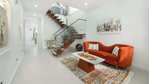 A modern living room with a staircase, a sofa, and a coffee table.