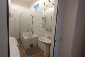 A bathroom with a bathtub, a sink, and a shower.