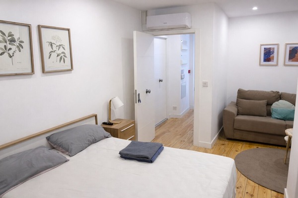 Bedroom with double bed and sofa in the same room