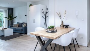 A modern dining area with a wooden table, white chairs, and a minimalist decor.