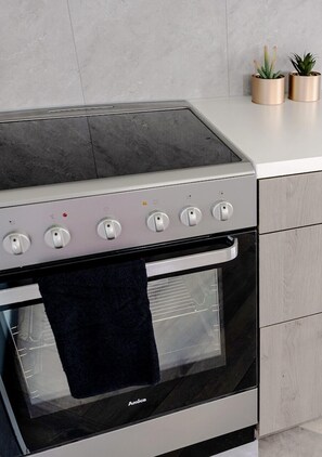 Een koffiezetapparaat/waterkoker, kookgerei, borden en bestek