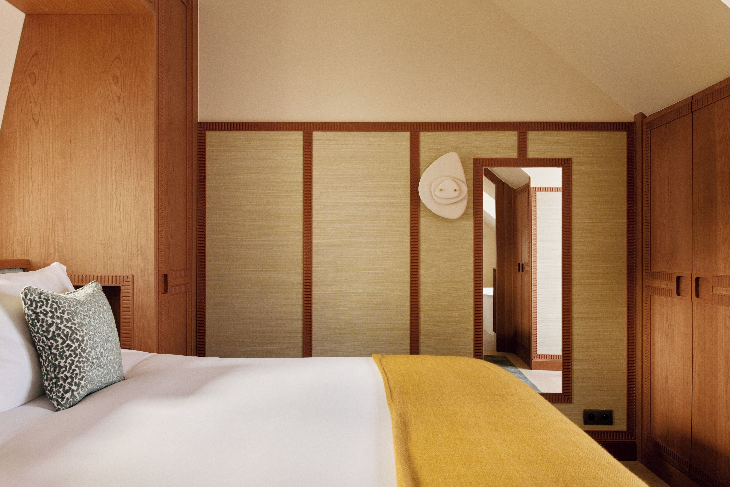 Une chambre d’hôtel avec un lit, une armoire en bois et une porte coulissante traditionnelle.