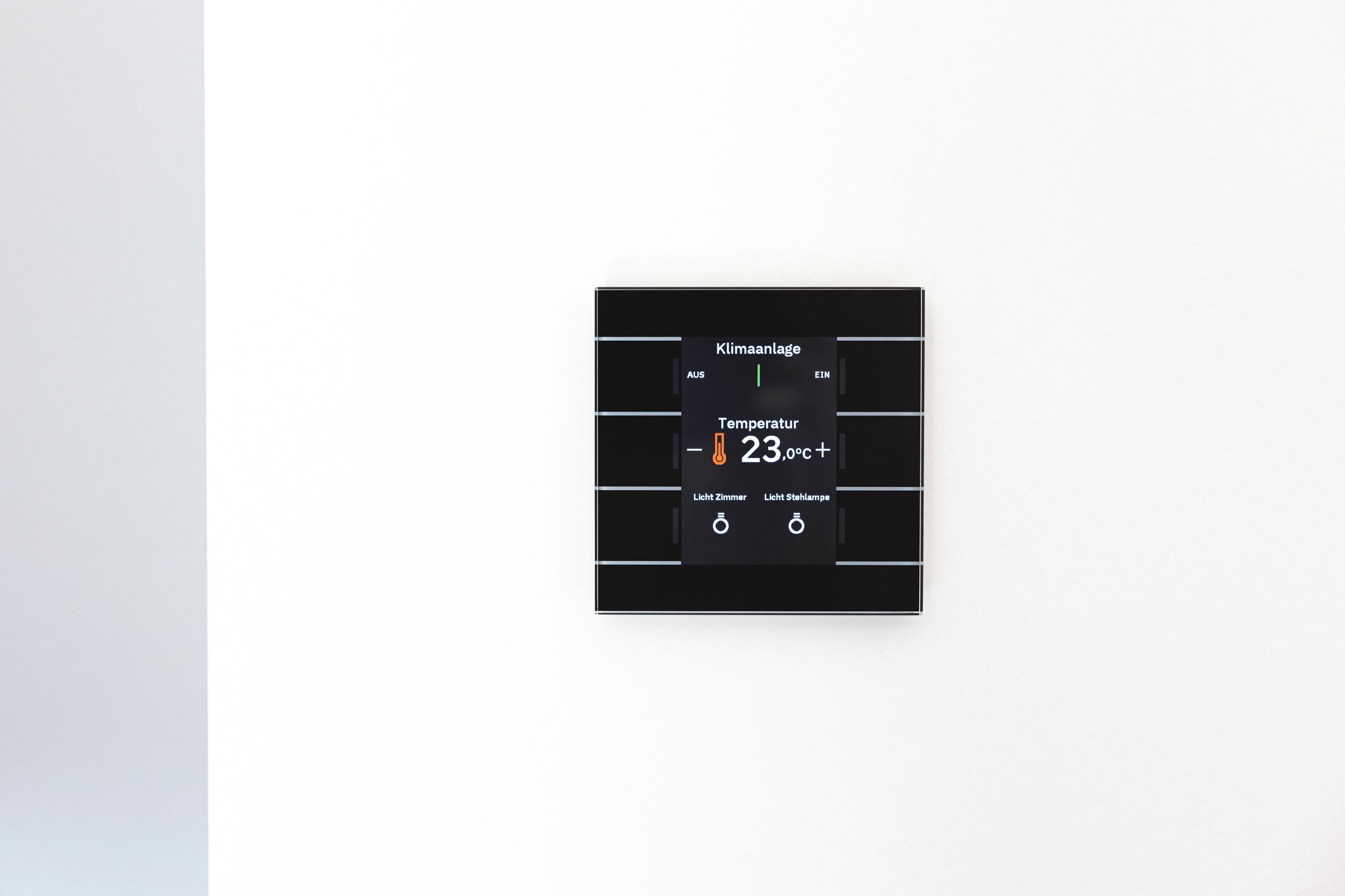 Termostato con pantalla que muestra 23,0°C, que incluye botones de control para la luz y la configuración del ventilador.