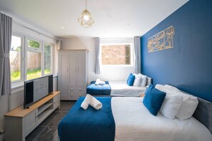 A hotel room with two beds, a TV, and a window with a view of greenery. - Cosy Garden Studio l Free Parking, WiFi l Sleeps 3 (St Albans)