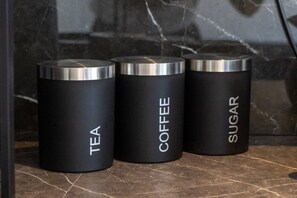Three cylindrical containers labeled tea, coffee, and sugar on a marble surface. - Cosy Garden Studio l Free Parking, WiFi l Sleeps 3 (St Albans)