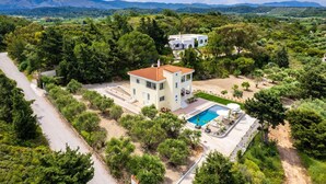 A two-story house with a swimming pool, surrounded by trees and hills. - Sunset View Paradisi Villa (Rhodes)