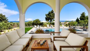 A covered outdoor seating area with a view of a pool and landscape. - Sunset View Paradisi Villa (Rhodes)