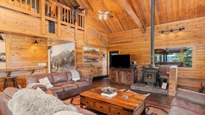 Ein gemütliches Blockhaus-Interieur mit Ledersofa, Holztisch und Kamin.