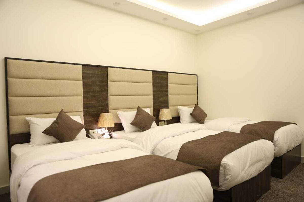 A hotel room with a large bed, two bedside tables, and a modern headboard.
