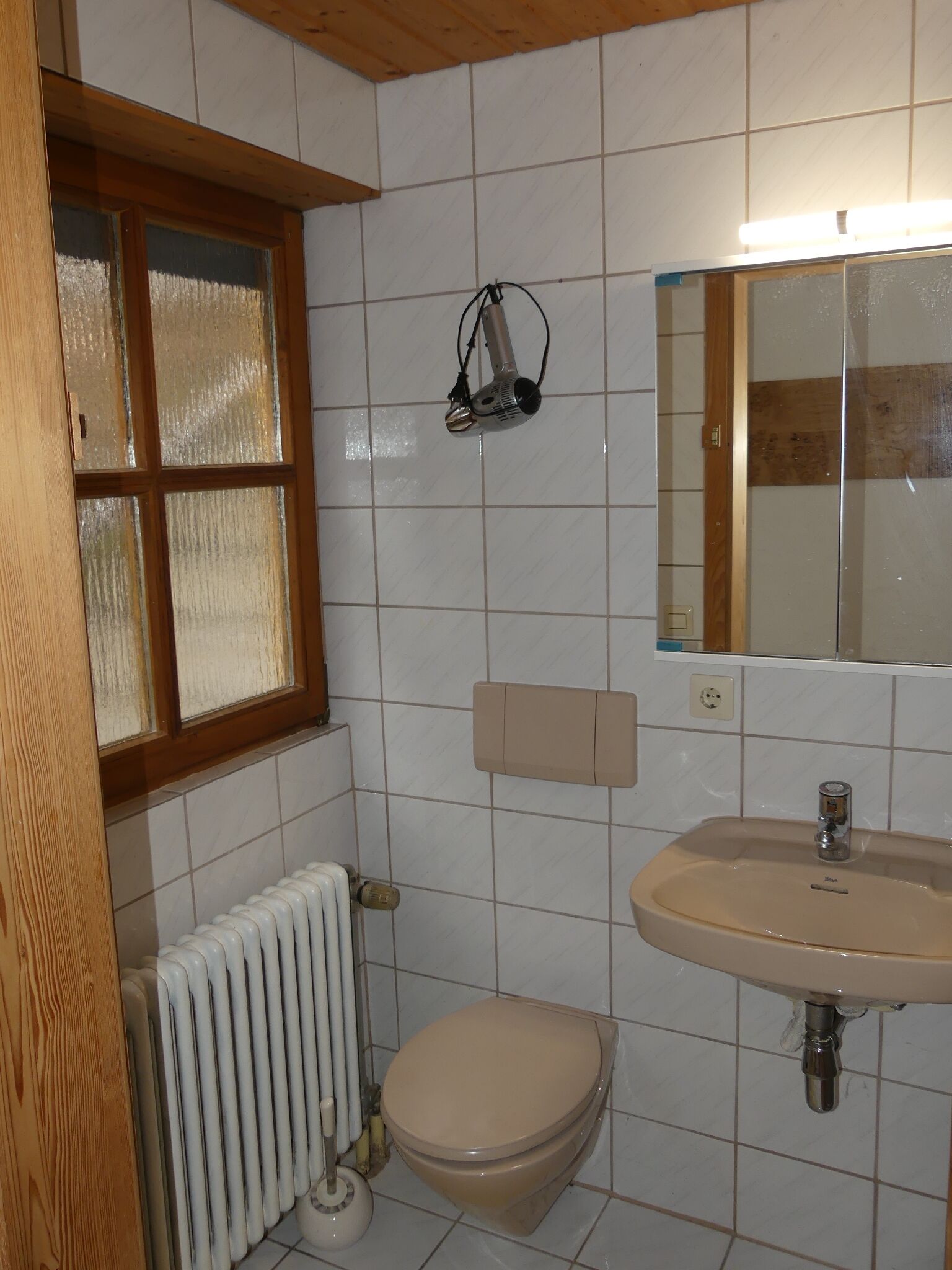 Un baño con inodoro, lavamanos y ventana.