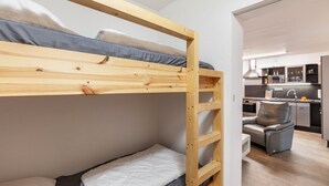 A bunk bed with a kitchen area in the background. - Holiday Apartment "Zum Segel" 2 with Private Terrace and Wi-Fi (Zadelsdorf)