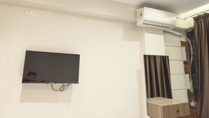 A modern room with a mounted flat-screen TV, a built-in air conditioning unit, and a wooden cabinet. - The Pyramid Vault View INN (Giza)