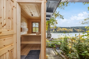 Una cabaña de madera con vistas a un lago y follaje otoñal.