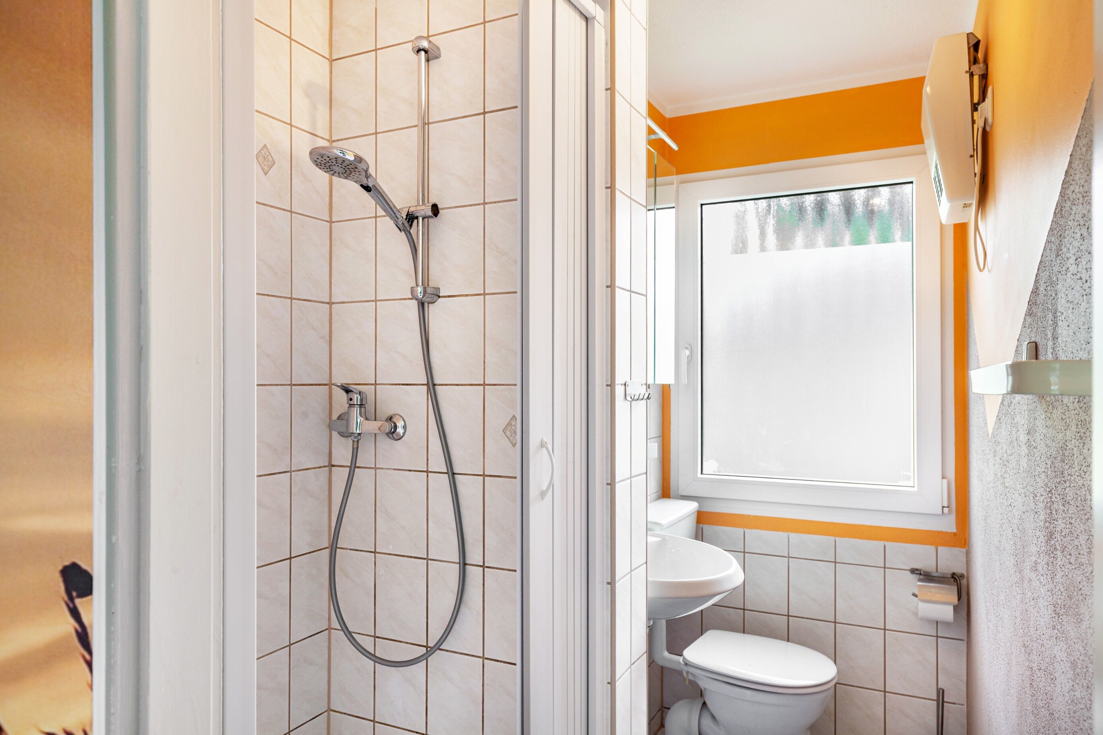 Un baño con ducha, inodoro y lavamanos.