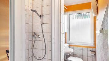 Un baño con ducha, inodoro y lavamanos.