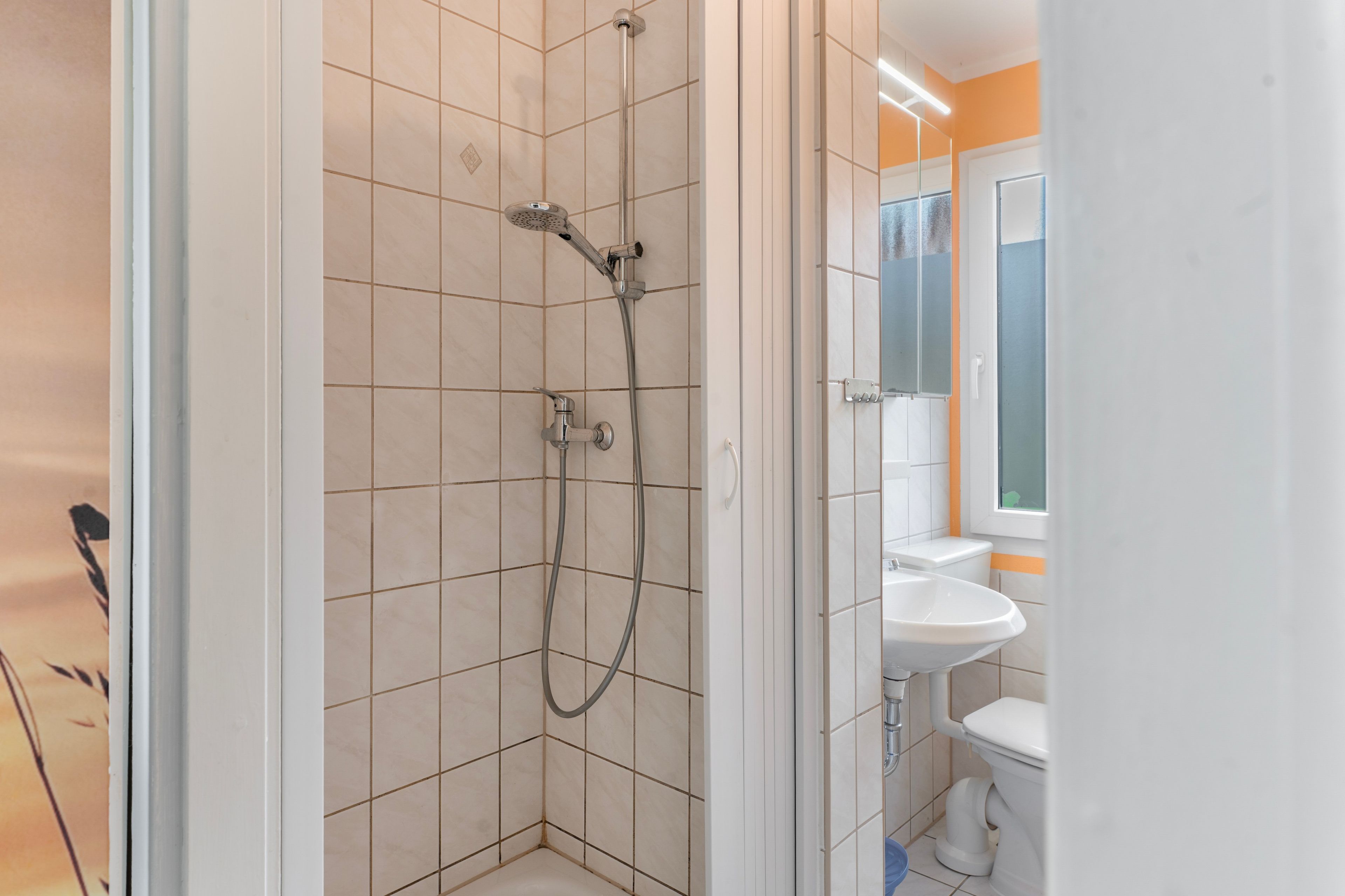 A bathroom with a shower, a toilet, and a sink.