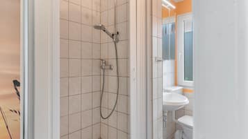 A bathroom with a shower, a toilet, and a sink.
