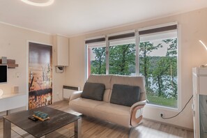Un salon moderne avec un canapé, une table basse et un tableau accroché au mur.