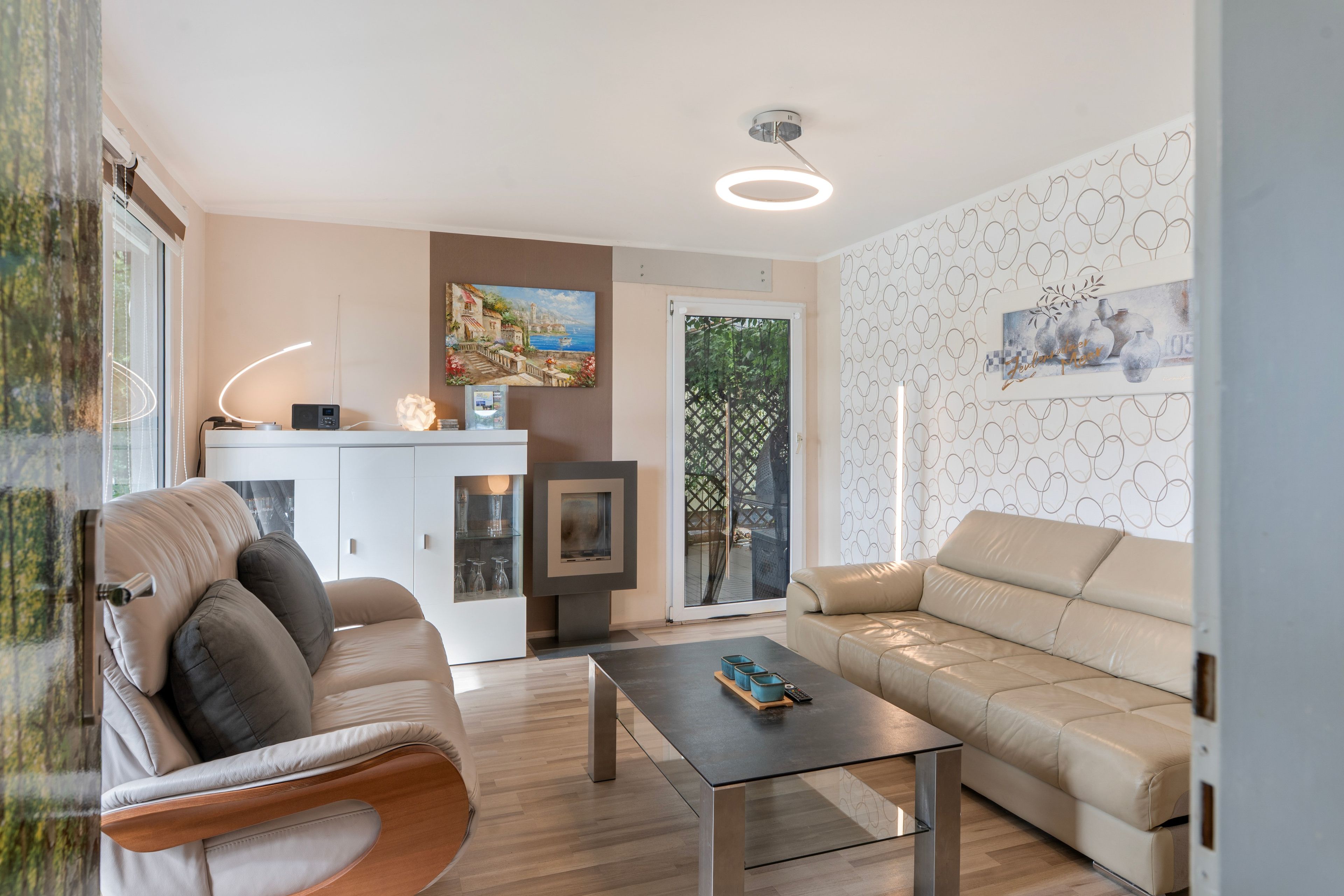 A modern living room with a sofa, a coffee table, and a painting on the wall.