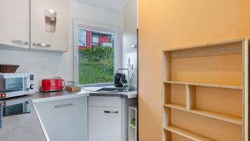 A compact kitchen with a microwave, toaster, and coffee maker.