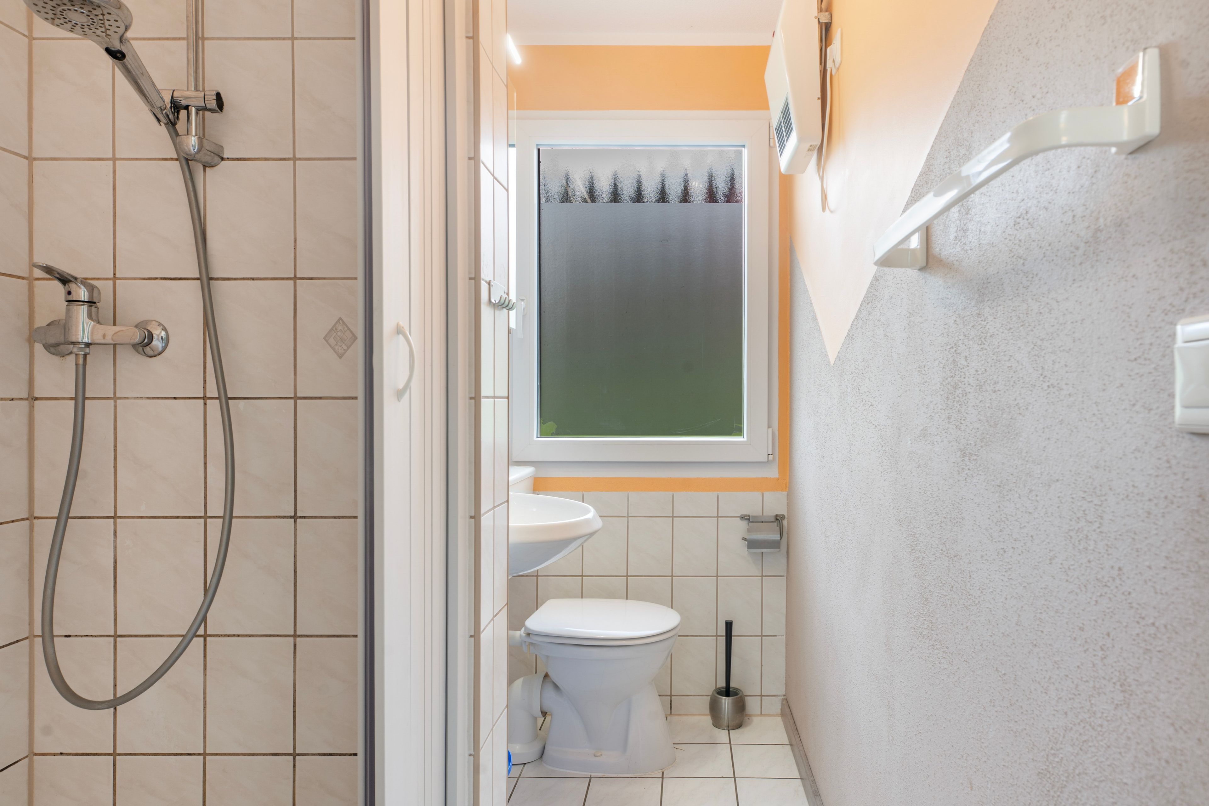 Ein Badezimmer mit Dusche, Toilette und Waschbecken.