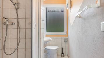 Ein Badezimmer mit Dusche, Toilette und Waschbecken.