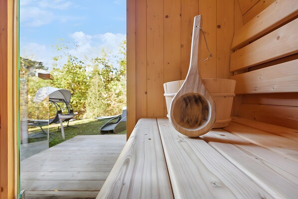 A wooden sauna bench with a wooden ladle and a white basin. - Holiday Home 219 with Lake View, Private Terrace and Wi-Fi (Zadelsdorf)