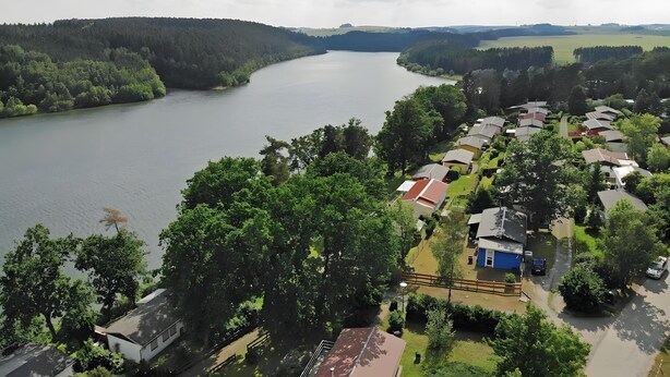Zona residencial junto al lago, con casas, un río y vegetación circundante.