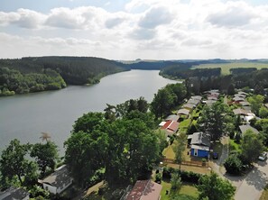 A lakeside residential area with houses, a river, and surrounding greenery. - Apartment “Zum Segel” 1 with Private Terrace and Wi-Fi (Zadelsdorf)