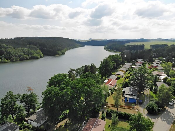 Zona residencial junto al lago, con casas, un río y vegetación circundante.