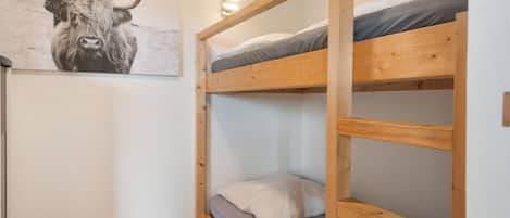 A bunk bed room with a bull's head artwork on the wall.