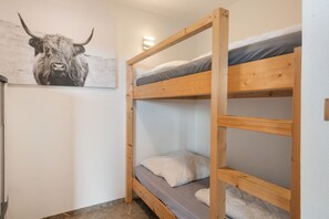 Habitación con literas y un cuadro de cabeza de toro en la pared.