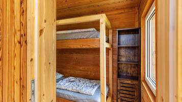 A wooden interior with bunk beds and a window.
