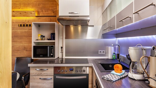 Een moderne keuken met een magnetron, oven en koffiezetapparaat.