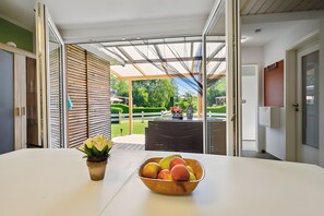 Una habitación con una mesa, un frutero y vistas a un jardín.