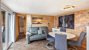 A modern interior with a sofa, chairs, a round table, and artwork on the walls. - Holiday Home 'Ferienhaus 34' with Private Terrace, Shared Garden and Wi-Fi (Zadelsdorf)