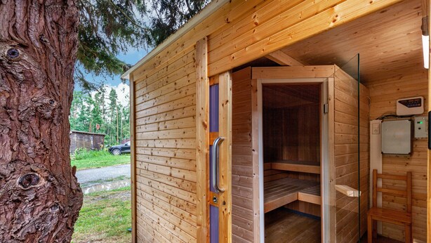 A wooden sauna with a glass door, a bench, and a control panel. - Holiday Home 'Ferienhaus 34' with Private Terrace, Shared Garden and Wi-Fi (Zadelsdorf)