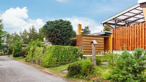 A residential property with a wooden exterior, a garage, and a driveway. - Holiday Home 'Ferienhaus 34' with Private Terrace, Shared Garden and Wi-Fi (Zadelsdorf)